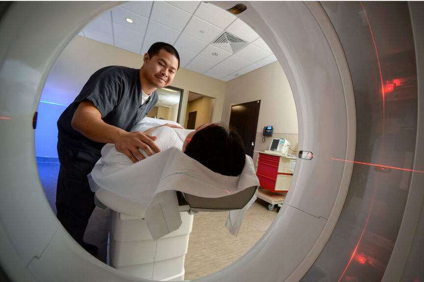 An imaging tech scans a patient