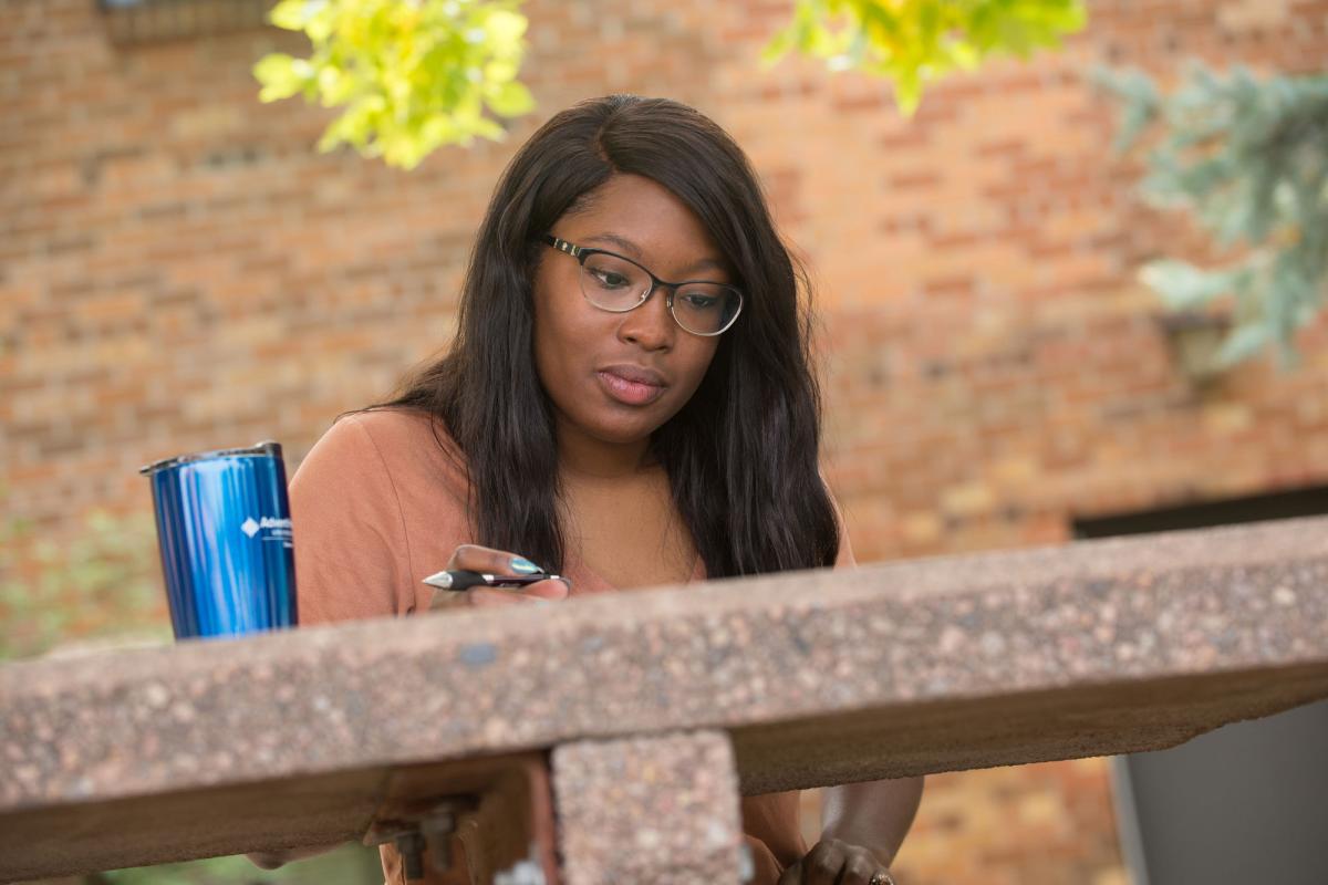 A female student studying outdoors at a picnic table