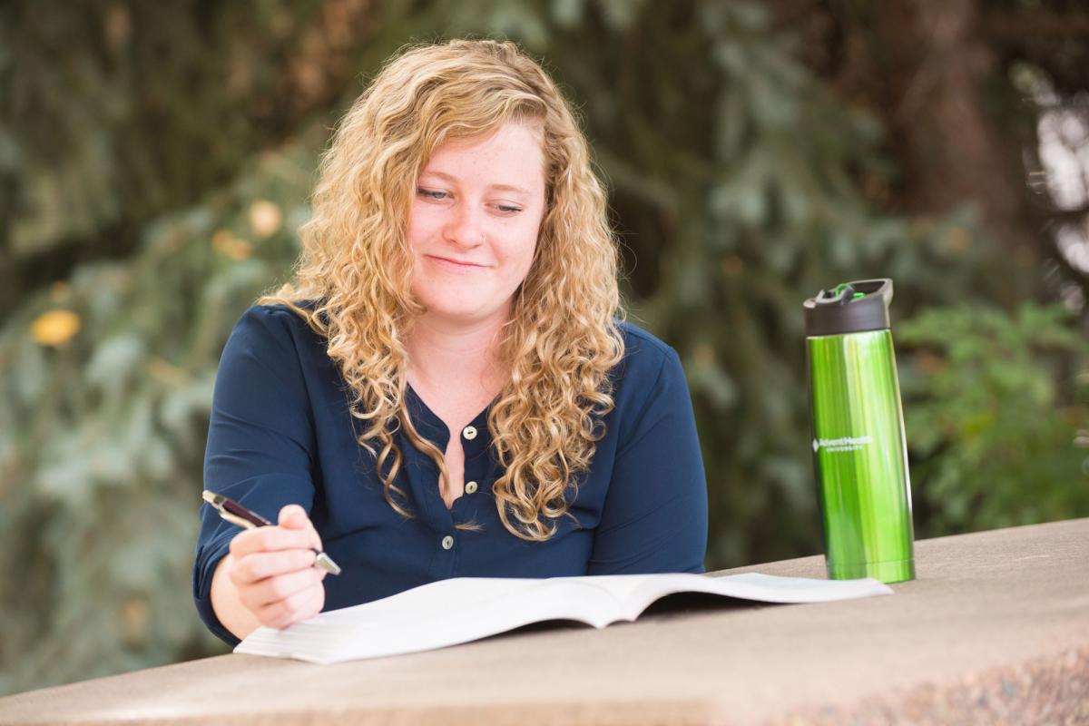 A female student studying outdoors at a picnic table