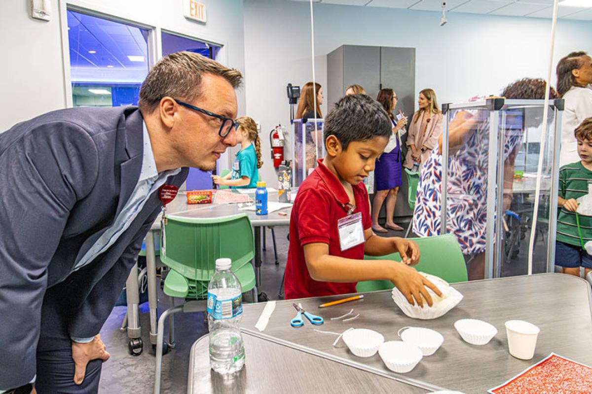 Development Office Julian Torreblanca observes boy conducting experiment