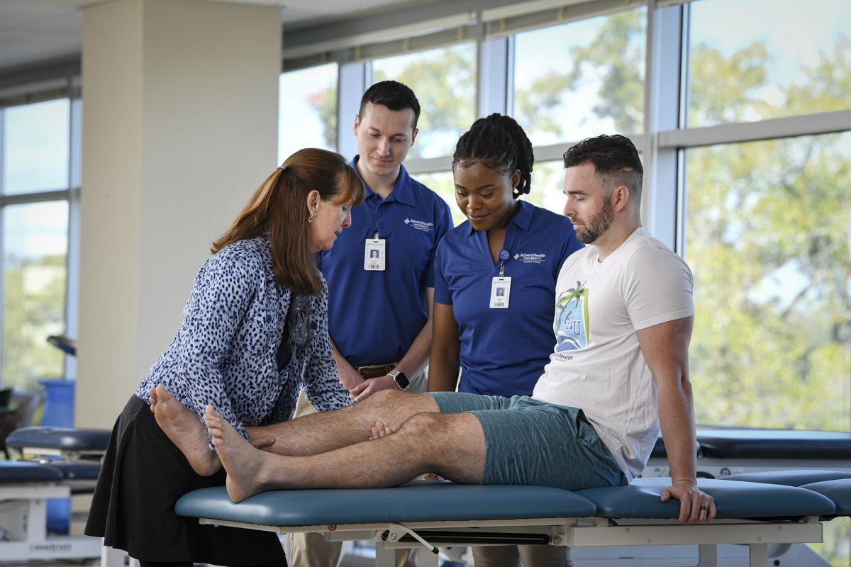 Physical Therapy students and professor examining a patient's leg