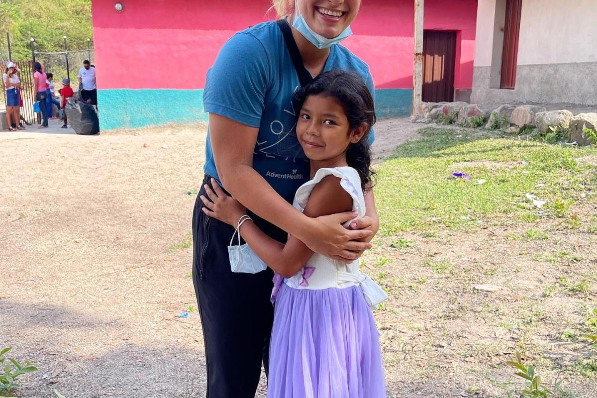 A physical therapy student with a young girl in honduras