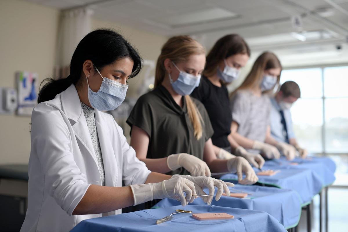 A group of PA students practicing suturing in the lab