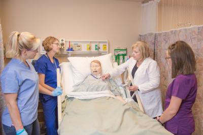 A nursing faculty member teaching students in the skills lab