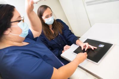 2 female students practicing skills for x-ray images of the hand