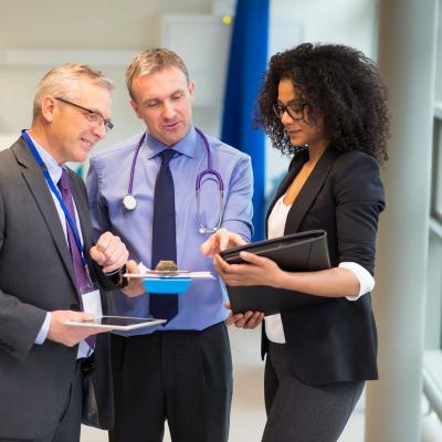 A doctor converses with healthcare consultants in a hospital