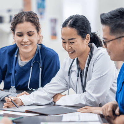 A group of nurses reviews documents at a table