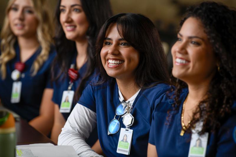 four smiling students in classroom on campus