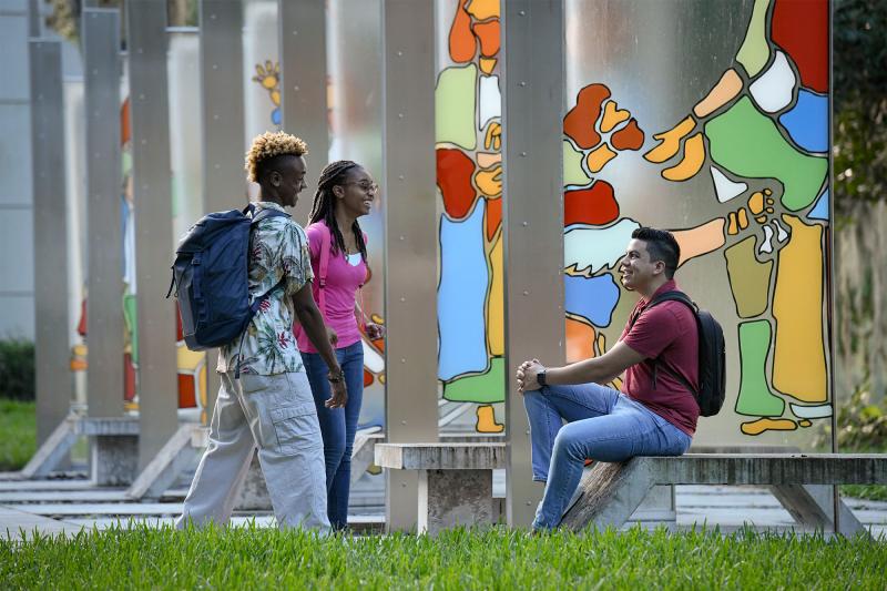 Three students conversing outdoors in AHU's Garden of Miracles