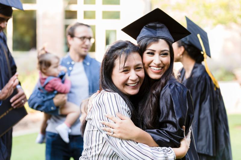 A female graduate hugs her mother