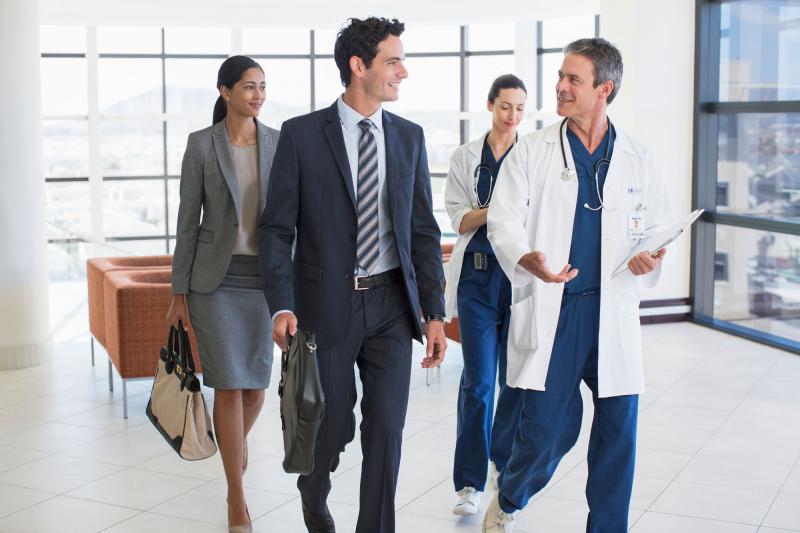 A doctor conversing with an administration team while walking