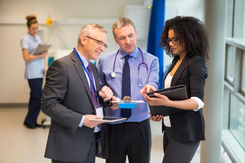 A doctor converses with healthcare consultants in a hospital