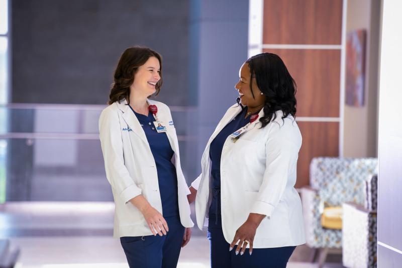 nurses in hallway smiling at each other