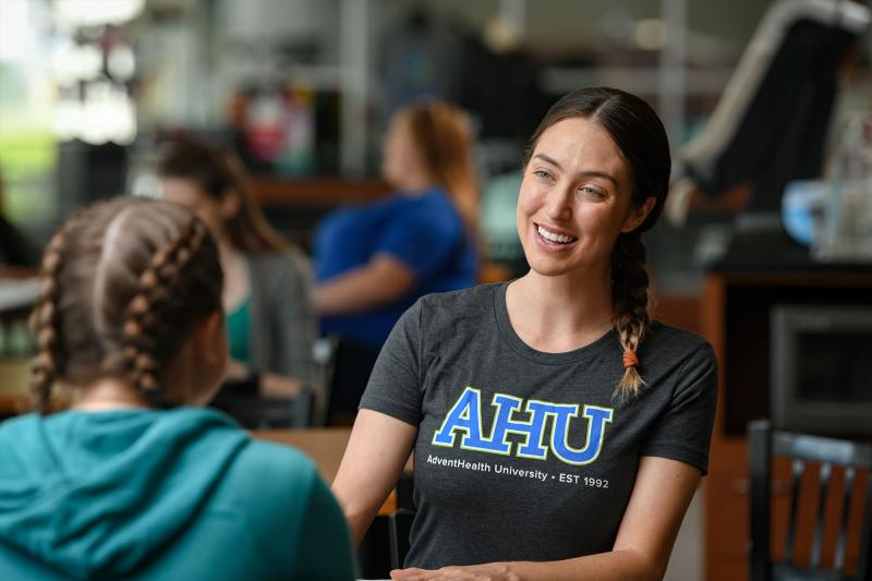 A current student conversing with a new student during orientation