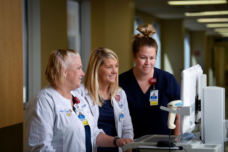 A nursing director and two employees viewing a monitor
