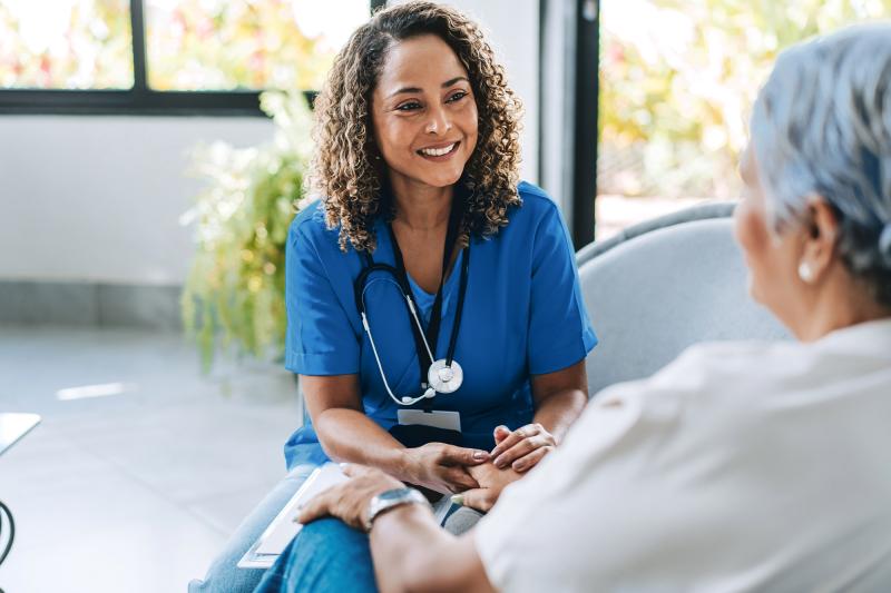 A nurse practitioner converses with a patient