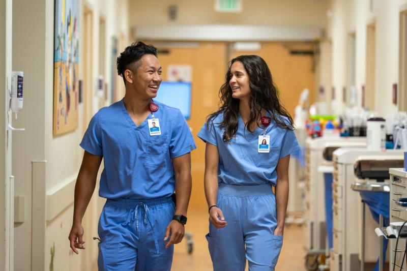 Two nurses smiling in hallway