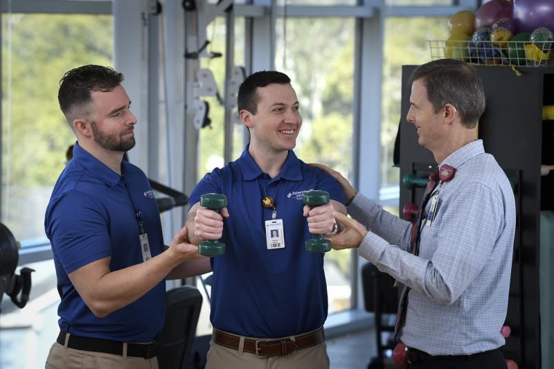 Physical Therapy students and professor using weights