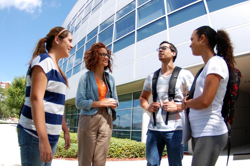A group of students conversing outside of AHU's Campus Center building