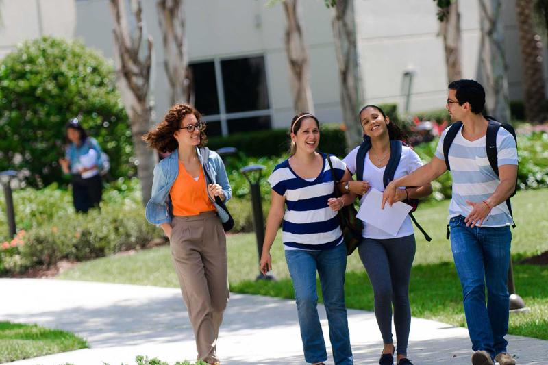 A group of students walks outside on campus
