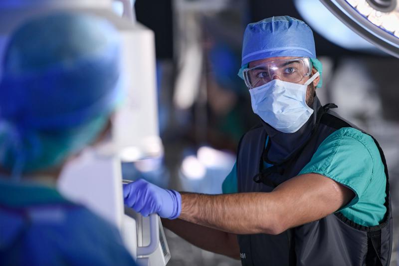 A healthcare worker operating an imaging machine during surgery
