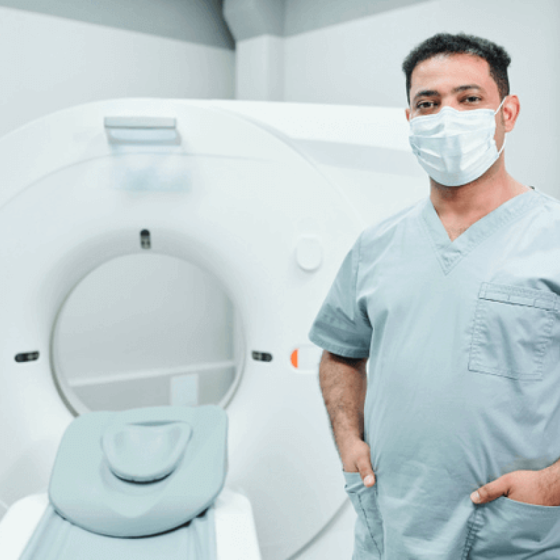 Tech in front of CT Machine