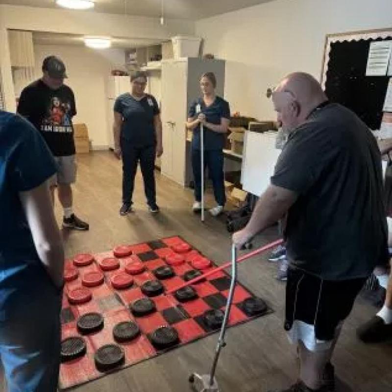 AHU students and faculty playing checkers with patients
