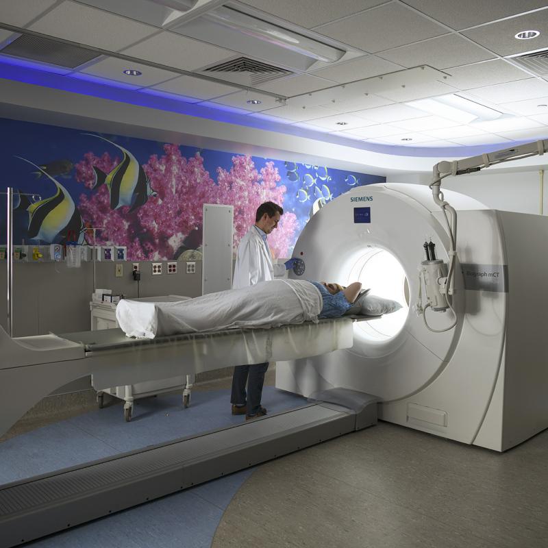 Physician performing PET scan on patient