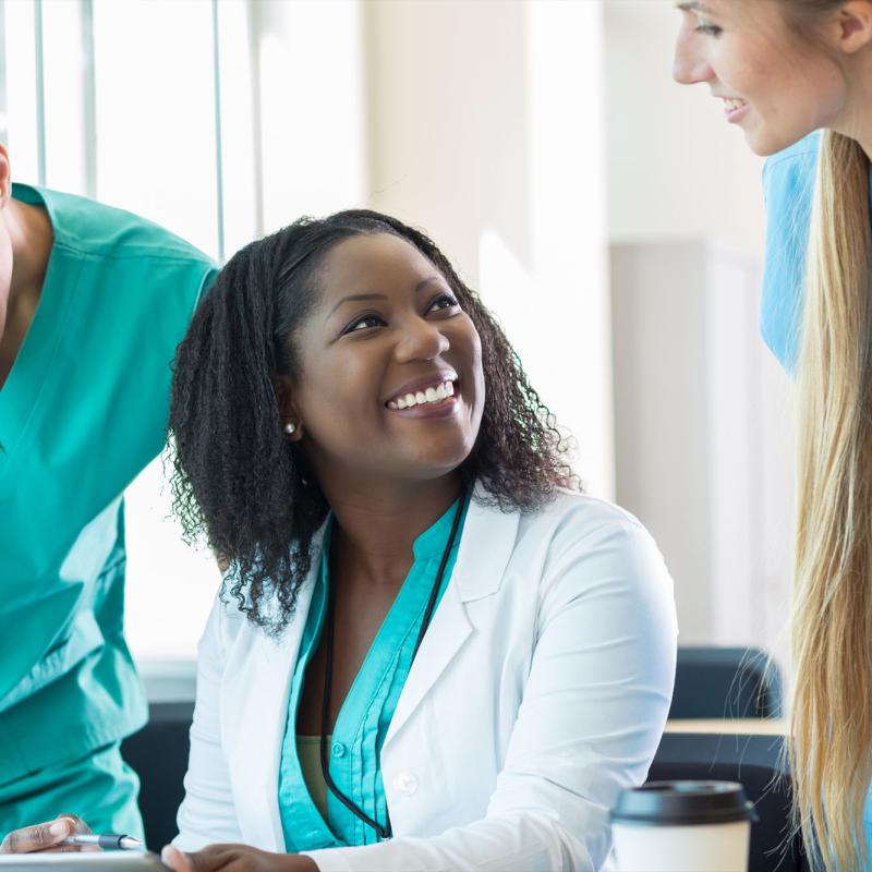 A group of nurses converses in a hospital setting