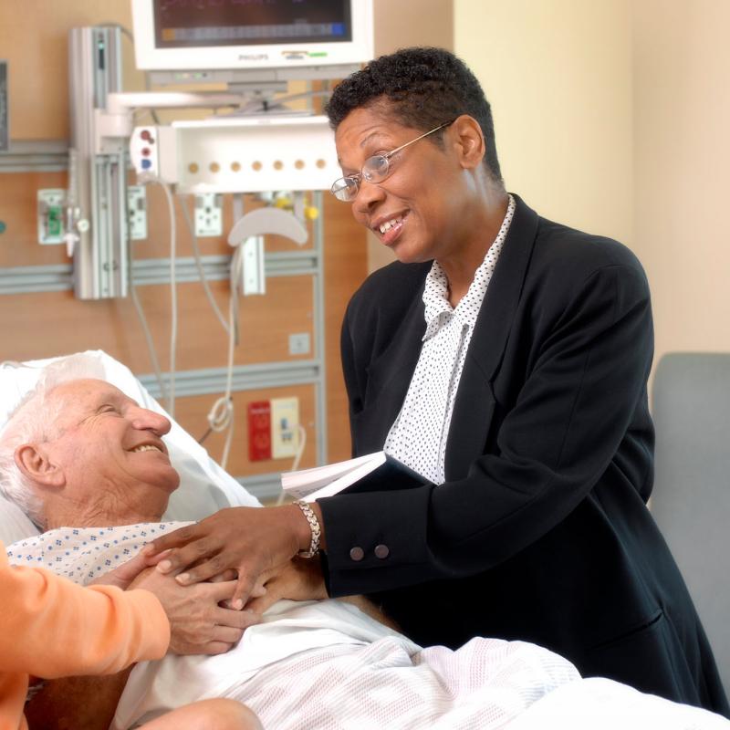 A hospital chaplain meets with a patient and family member