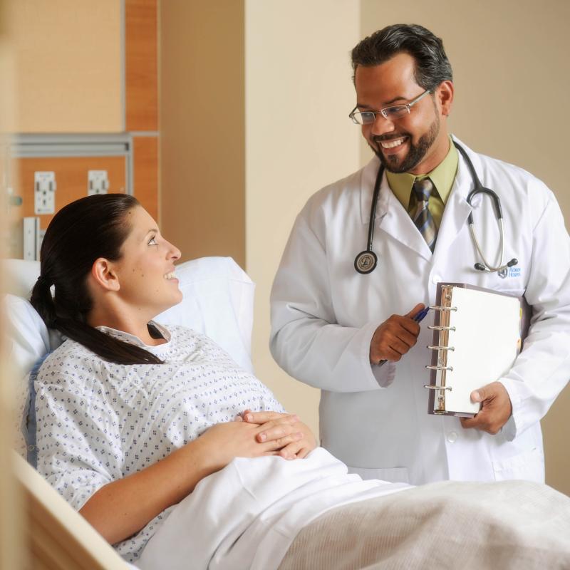 Doctor talking with patient in hospital bed