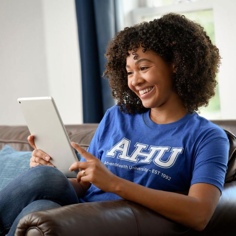 A female AHU students uses and ipad at her home