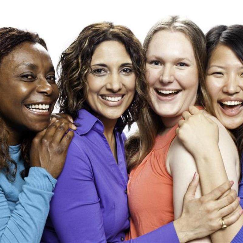 four women standing in a group smiling