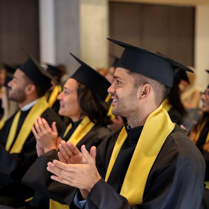 Graduates applauding during a graduation ceremeny