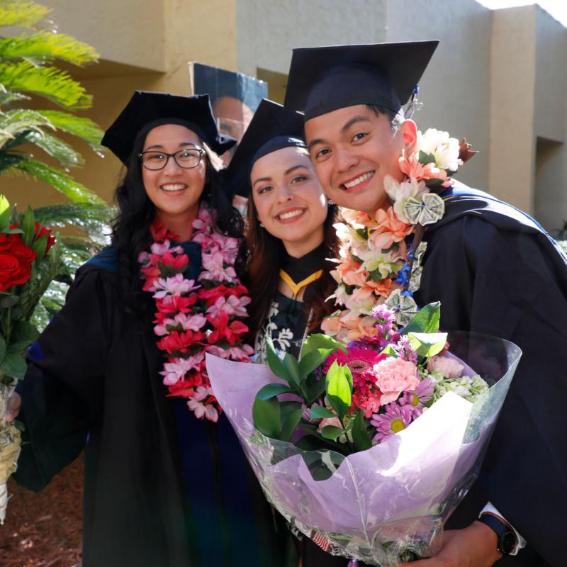 A group of graduates posing for a photo outdoors