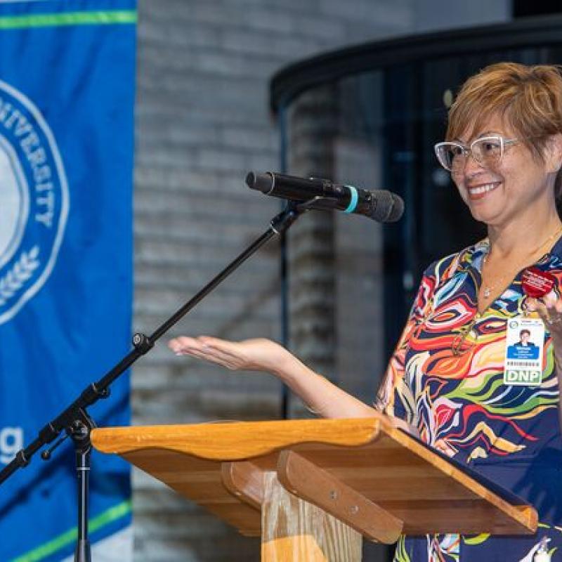 image of alumni smiling and giving a speech