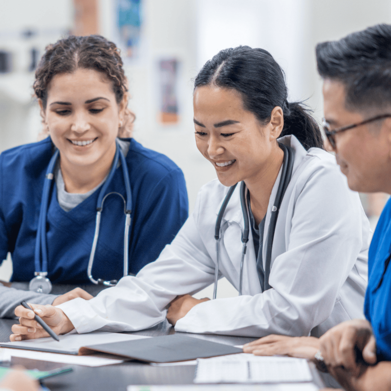 A group of nurses reviews documents at a table
