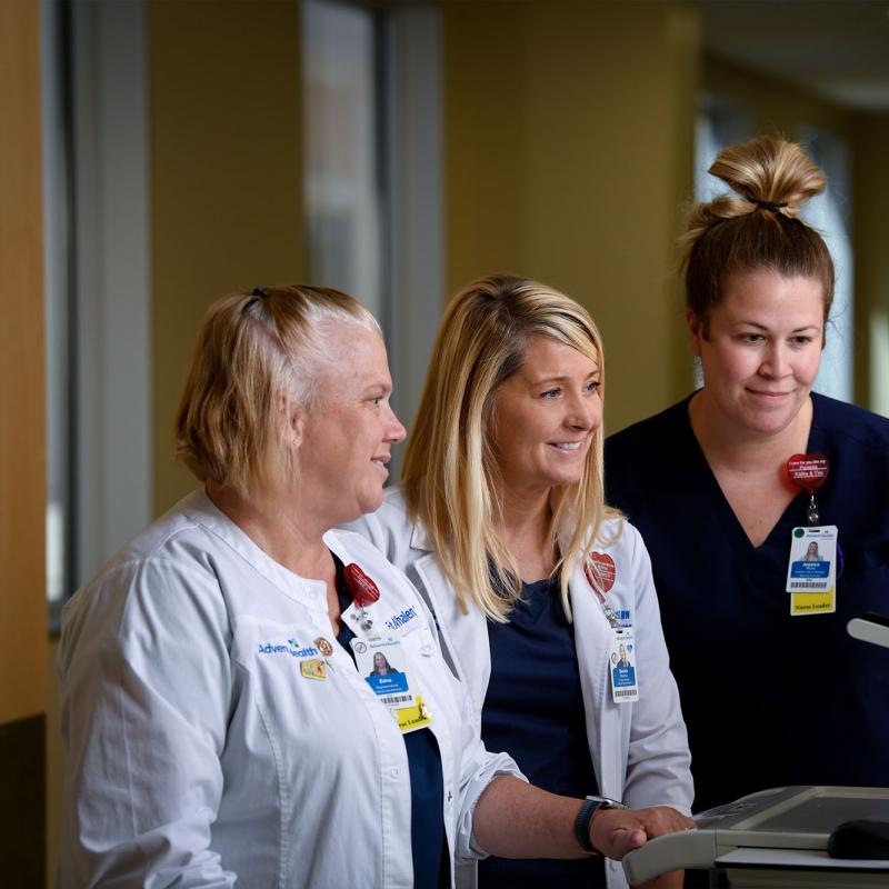 A nursing director and two employees viewing a monitor