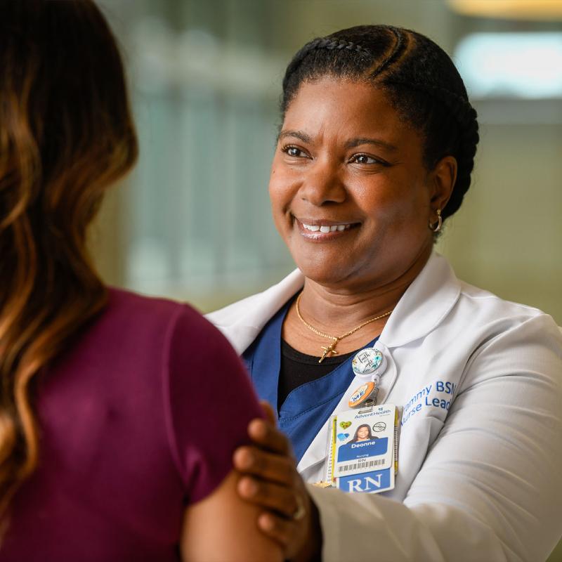 A nurse practitioner puts her hand on a person's shoulder