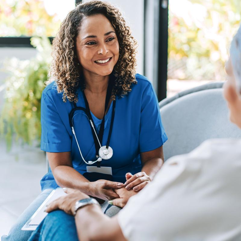 A nurse practitioner converses with a patient