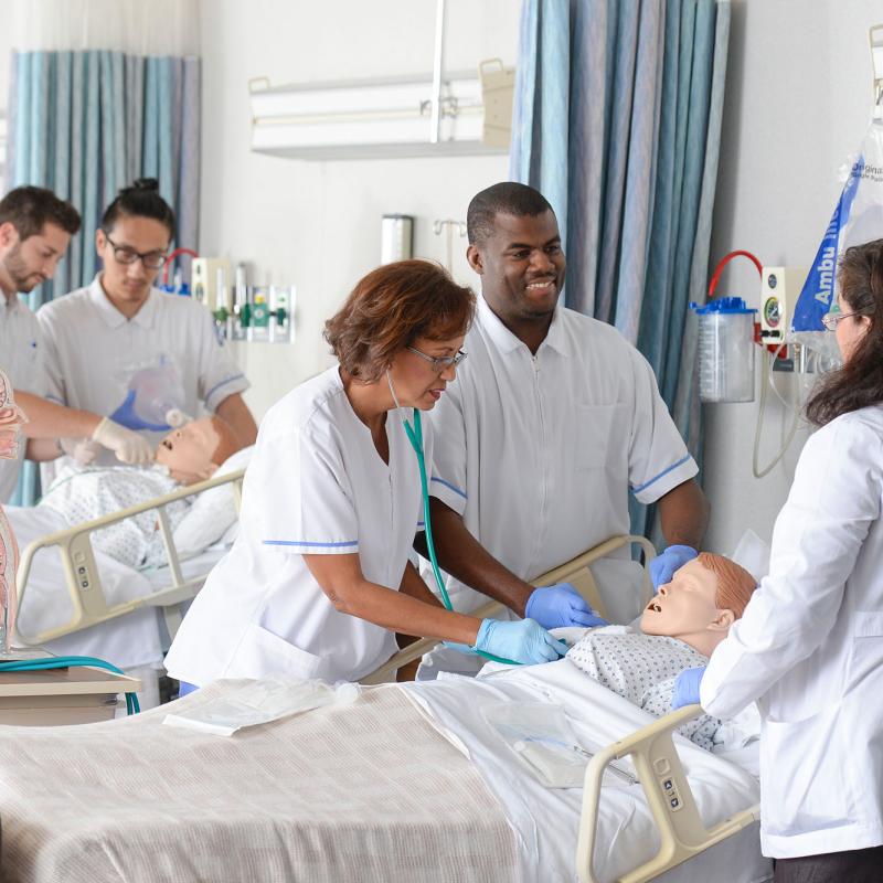 Nursing students practice their skills in the lab under faculty supervision