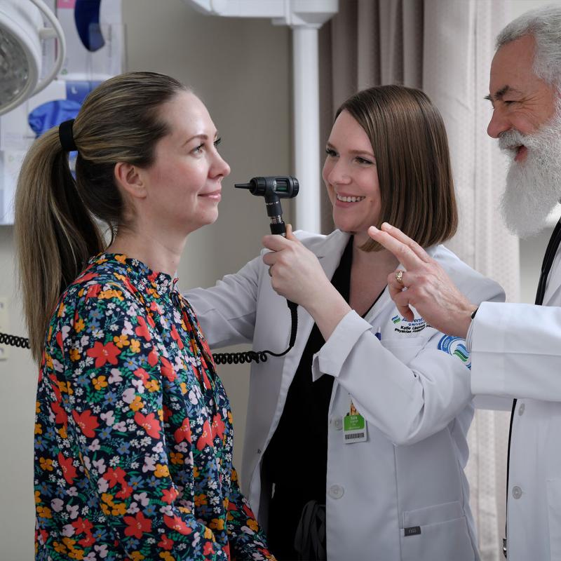A student examines a patient under faculty supervision