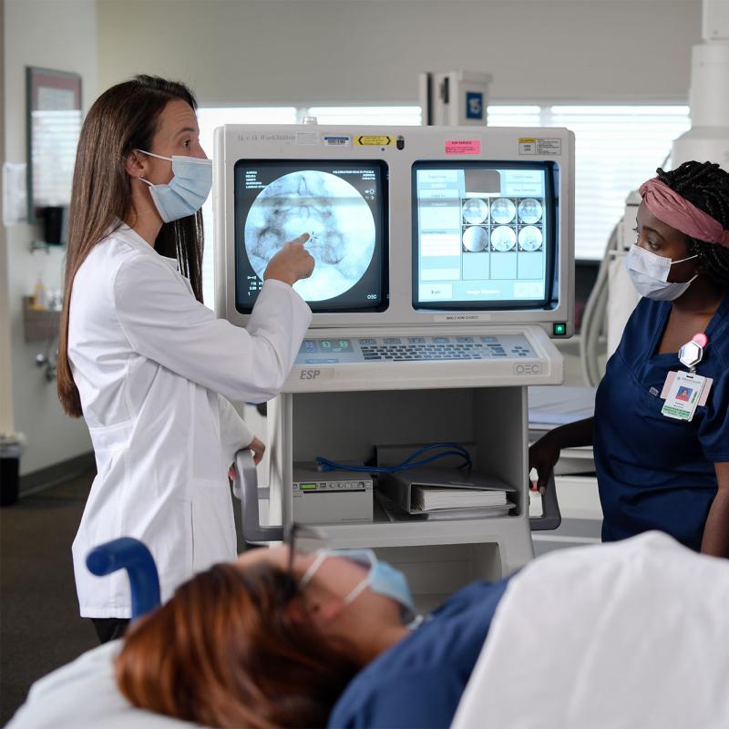 A radiography professor showing students an image on a monitor