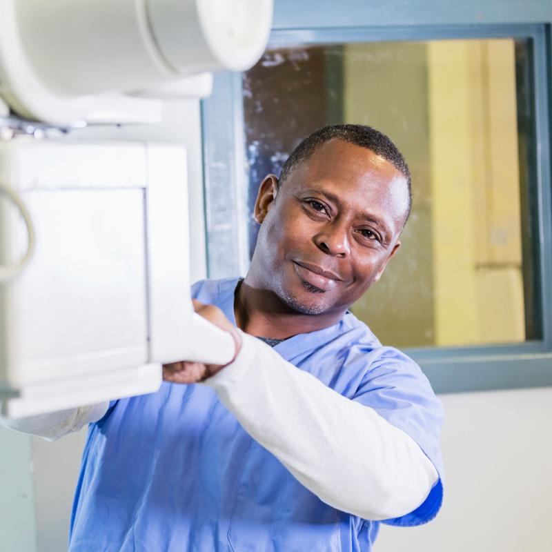 A male radiologic technologist getting ready to perform a scan.
