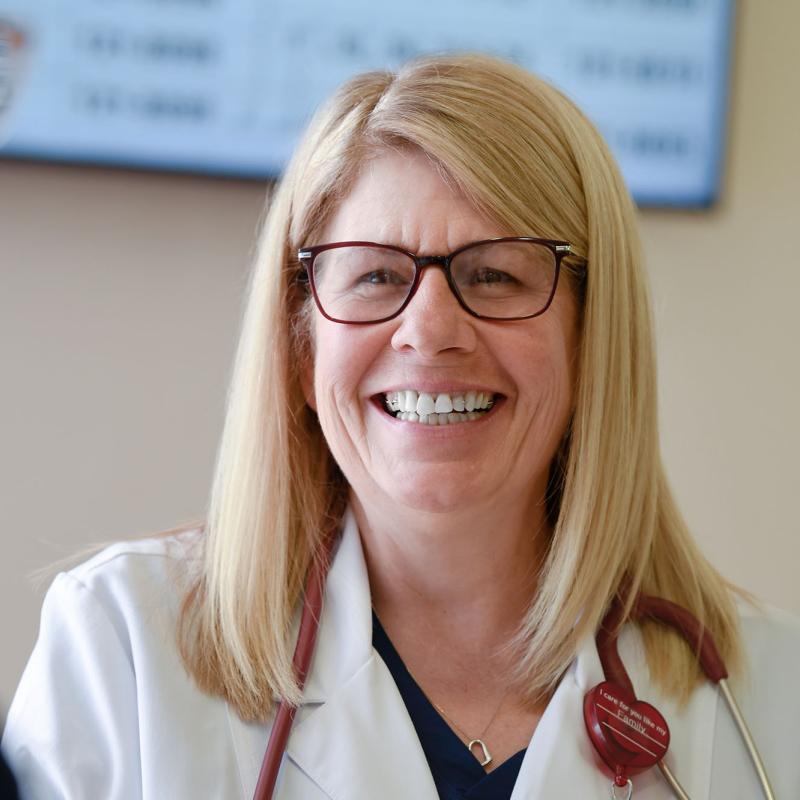 A nurse practitioner smiling at a coworker