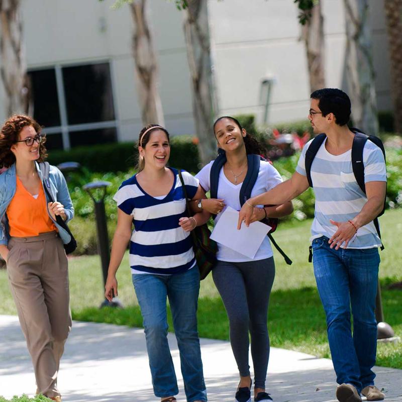 A group of students walking outside on AHU's campus