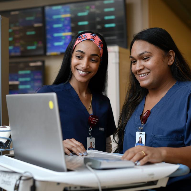 Young nurses viewing a computer on a mobile workstation