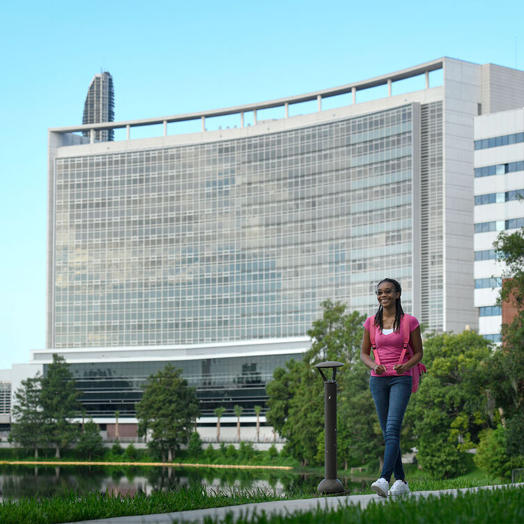 A student walks along the lake at AHU
