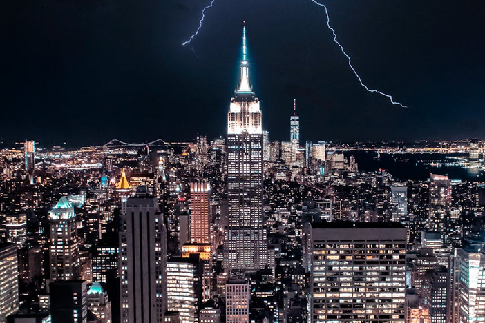 Dramatic view of NY skyline with lightning striking the Empire State Building.