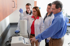A group of students using lab equipment under faculty supervision